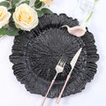 Black textured decorative plate with silver cutlery and floral accents.