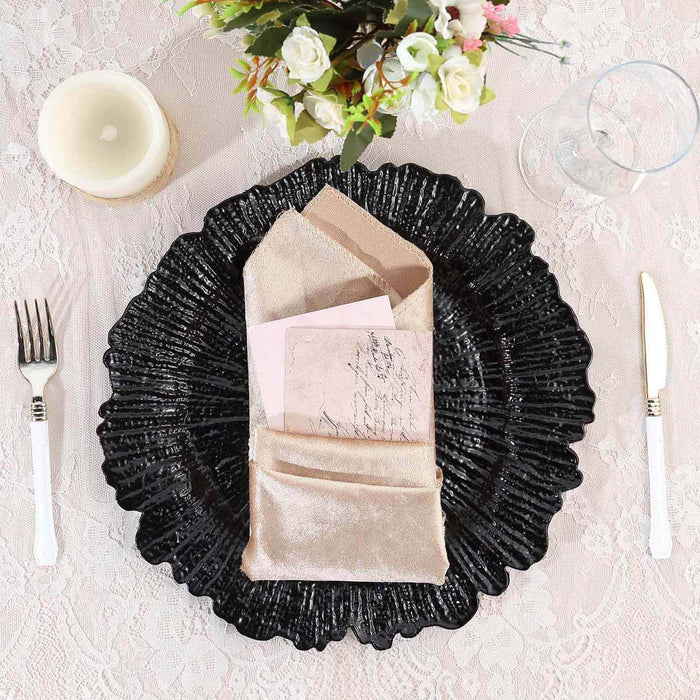Elegant black plate with gold napkins and decorative cards on a lace tablecloth.