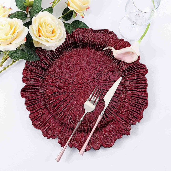 Elegant burgundy decorative plate with fork and knife, surrounded by flowers.