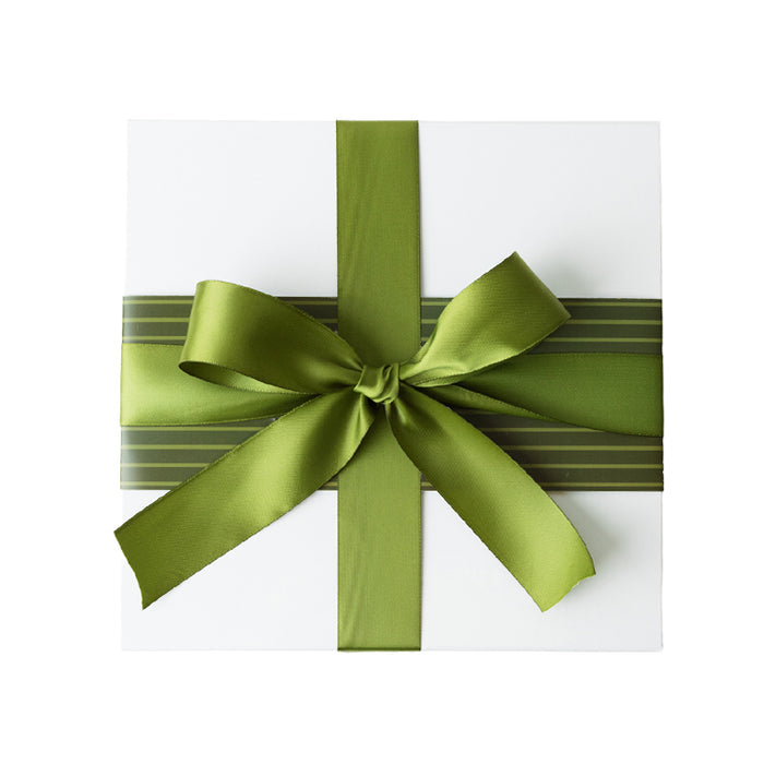 Gift box with a green ribbon and a light and dark green striped sleeve on a white background