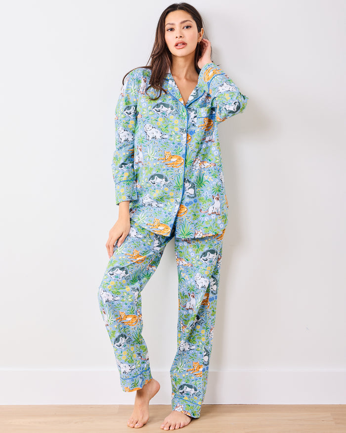 Full front view of a model wearing the blue long pajama set with cats, flowers, and greenery