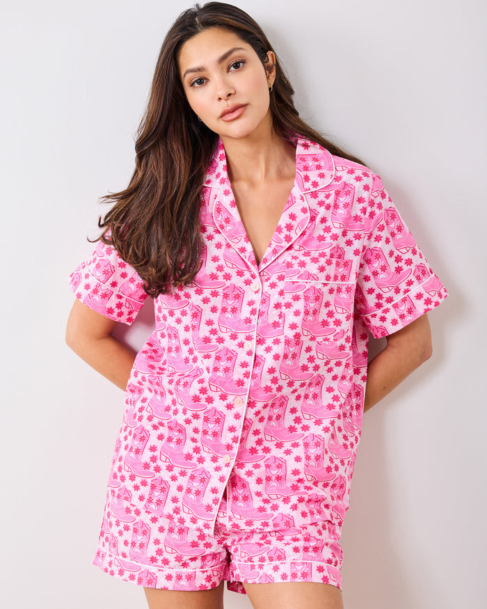 Front view of the party-pink short pajama set with cowboy boot and floral print.