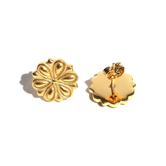 Gold floral earrings on a white background